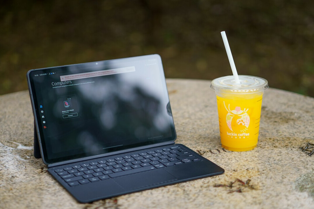 Laptop with programming code and a coffee cup
