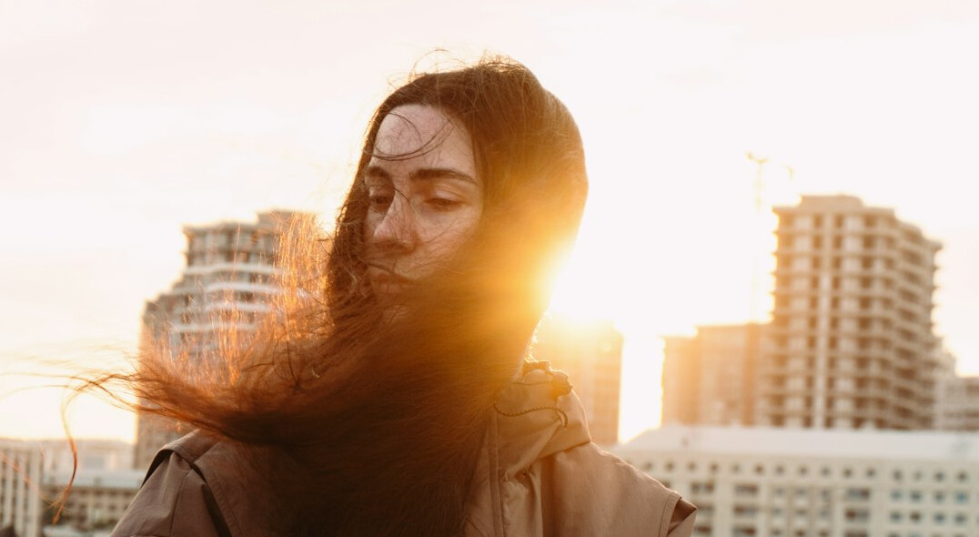 Portrait of a woman with long hair smiling outdoors